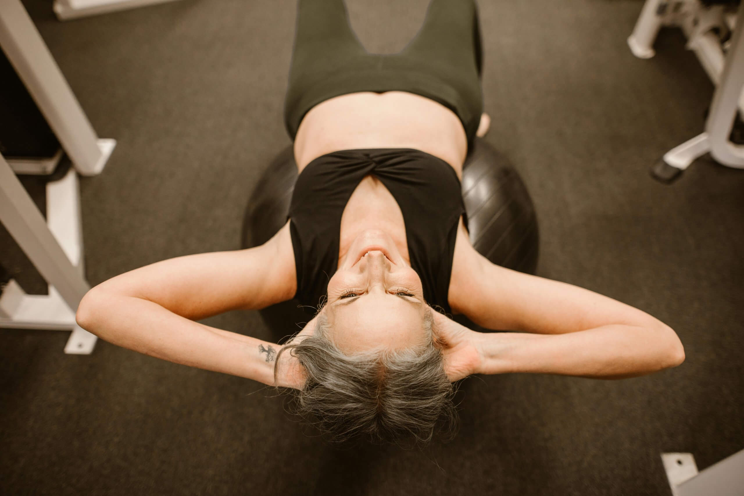 Femme en post-partum réalisant un exercice de renforcement sur un ballon pour retrouver sa forme physique après l’accouchement, dans le cadre d’un accompagnement ostéopathique à Ermont.