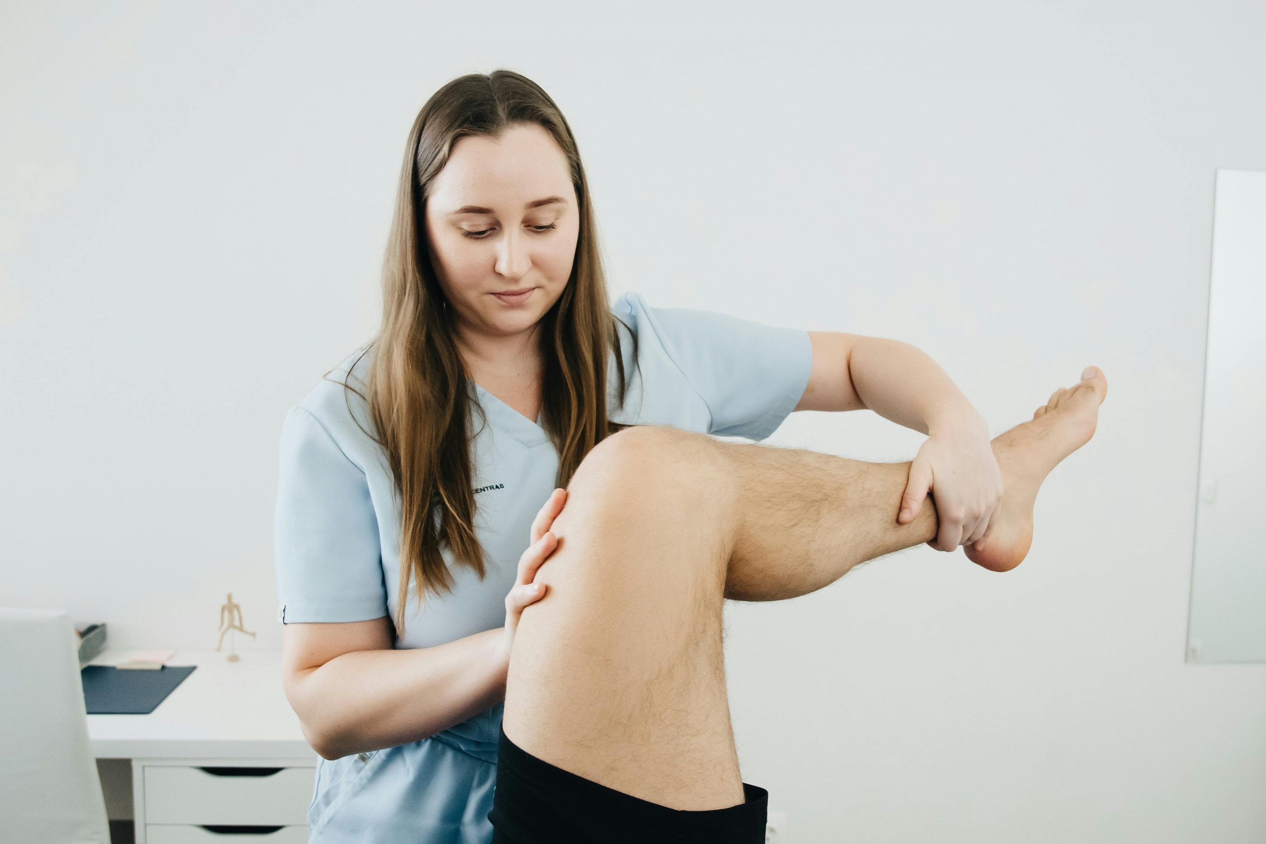 Ostéopathe réalisant un examen de la jambe chez un patient souffrant de fourmillements dans la jambe au cabinet de Saint-Gratien