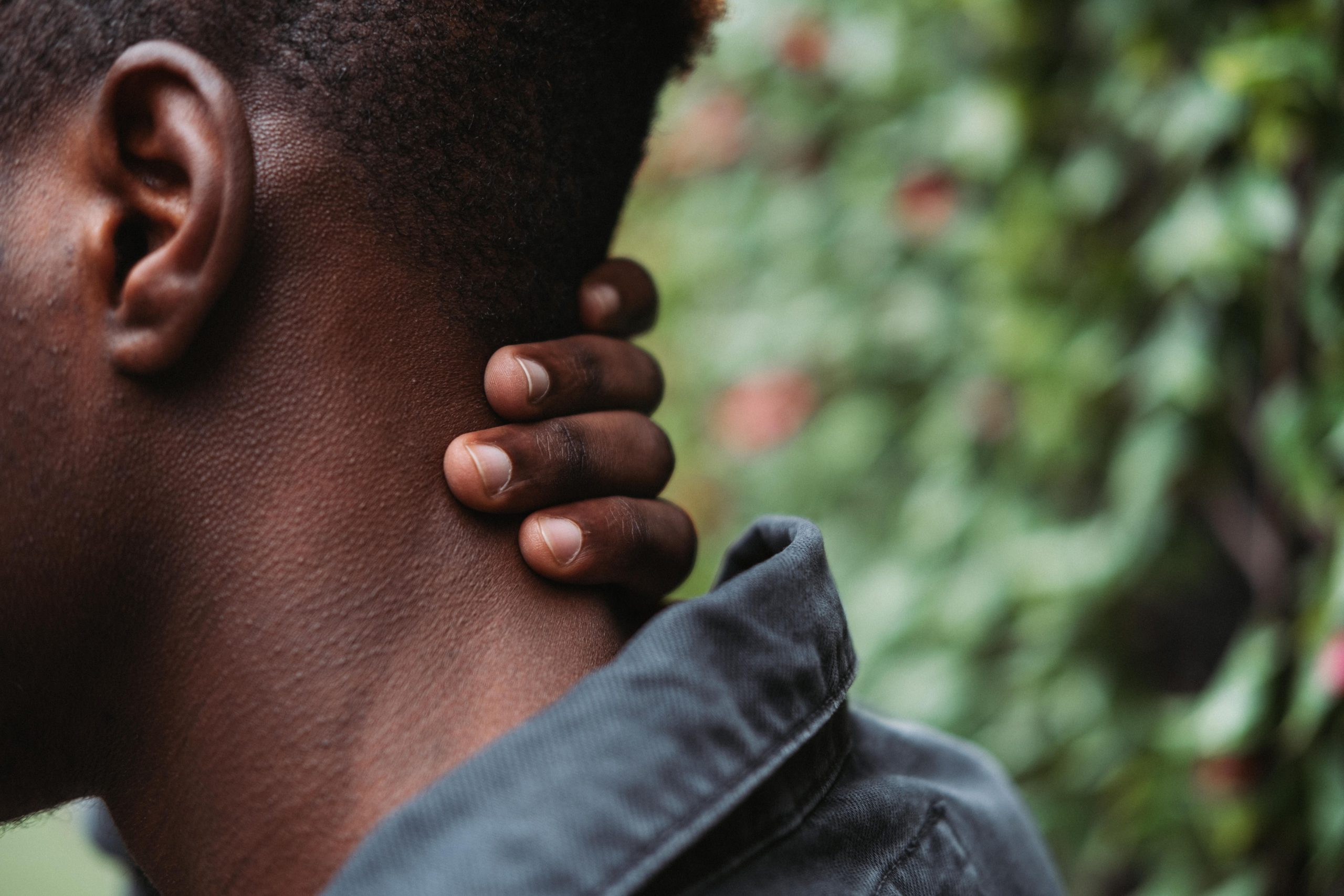 Personne souffrant d’une douleur cervicale et tenant sa nuque, illustration d’une tension au niveau du cou.