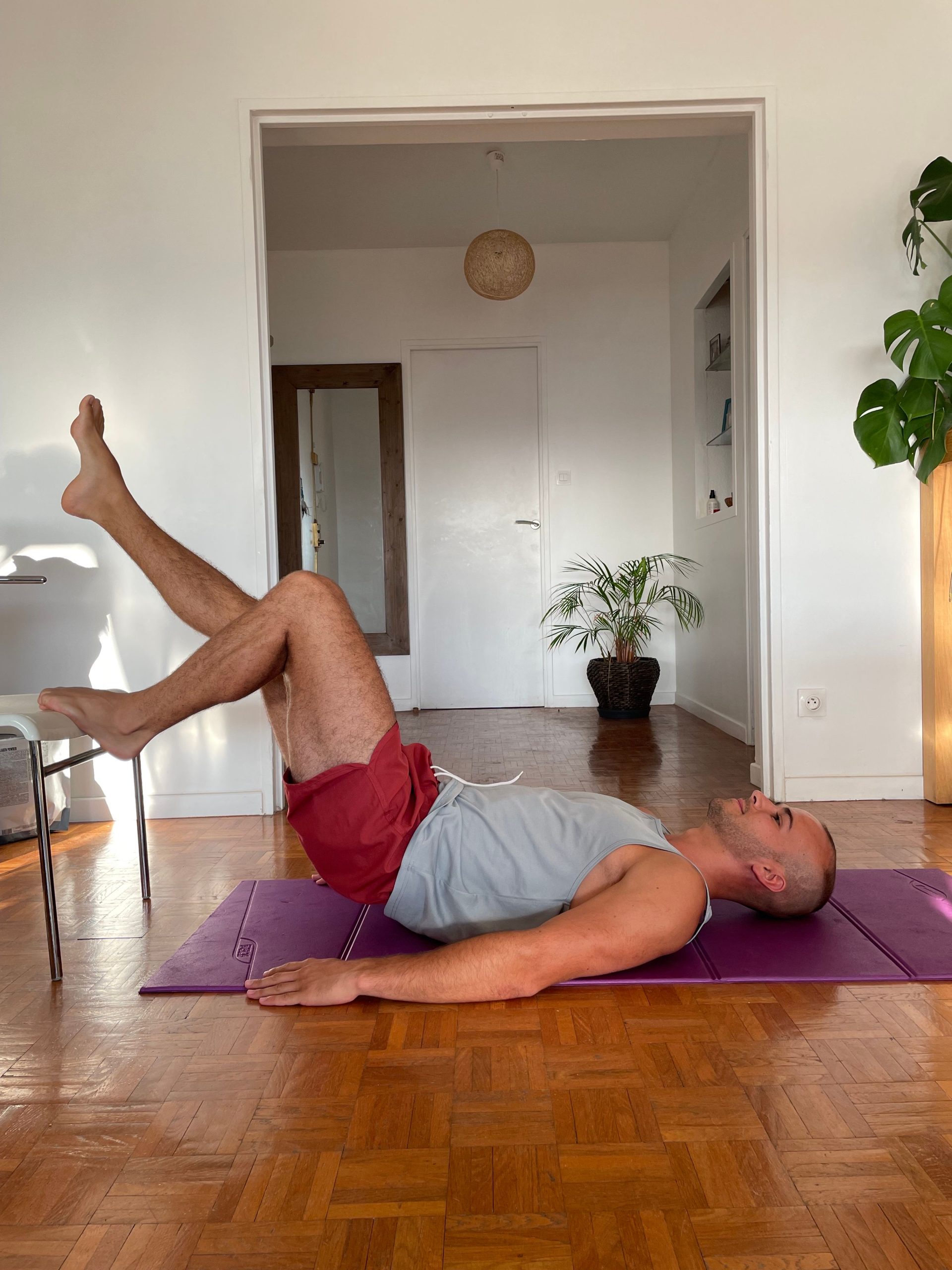 Homme réalisant un exercice de mobilité du nerf sciatique, allongé sur le dos, dans le cadre d’exercices pour soulager une sciatique.